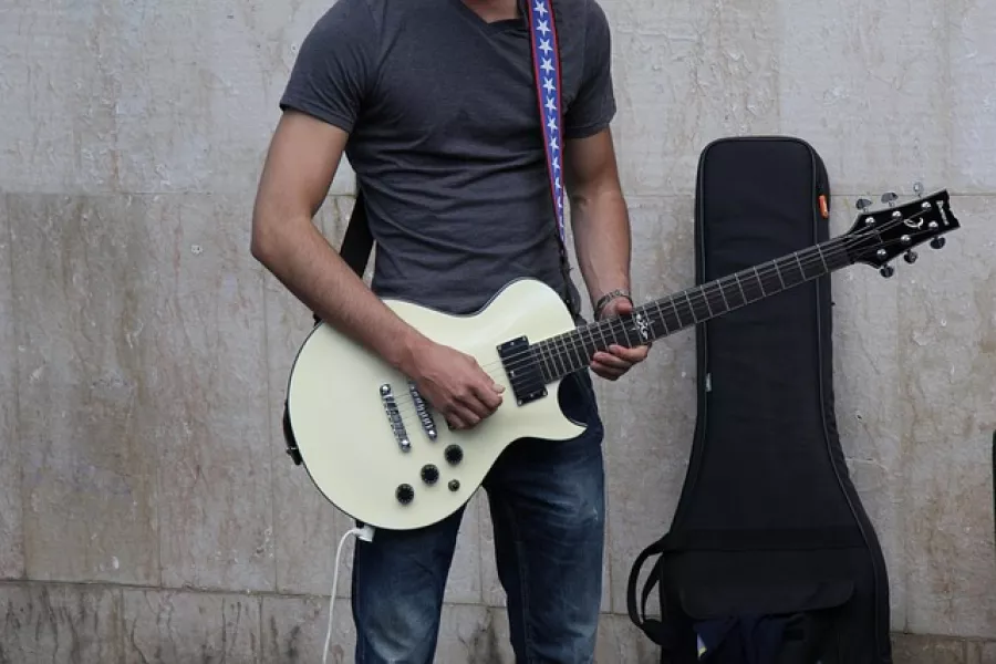 Mann spielt Gitarre im Stehen